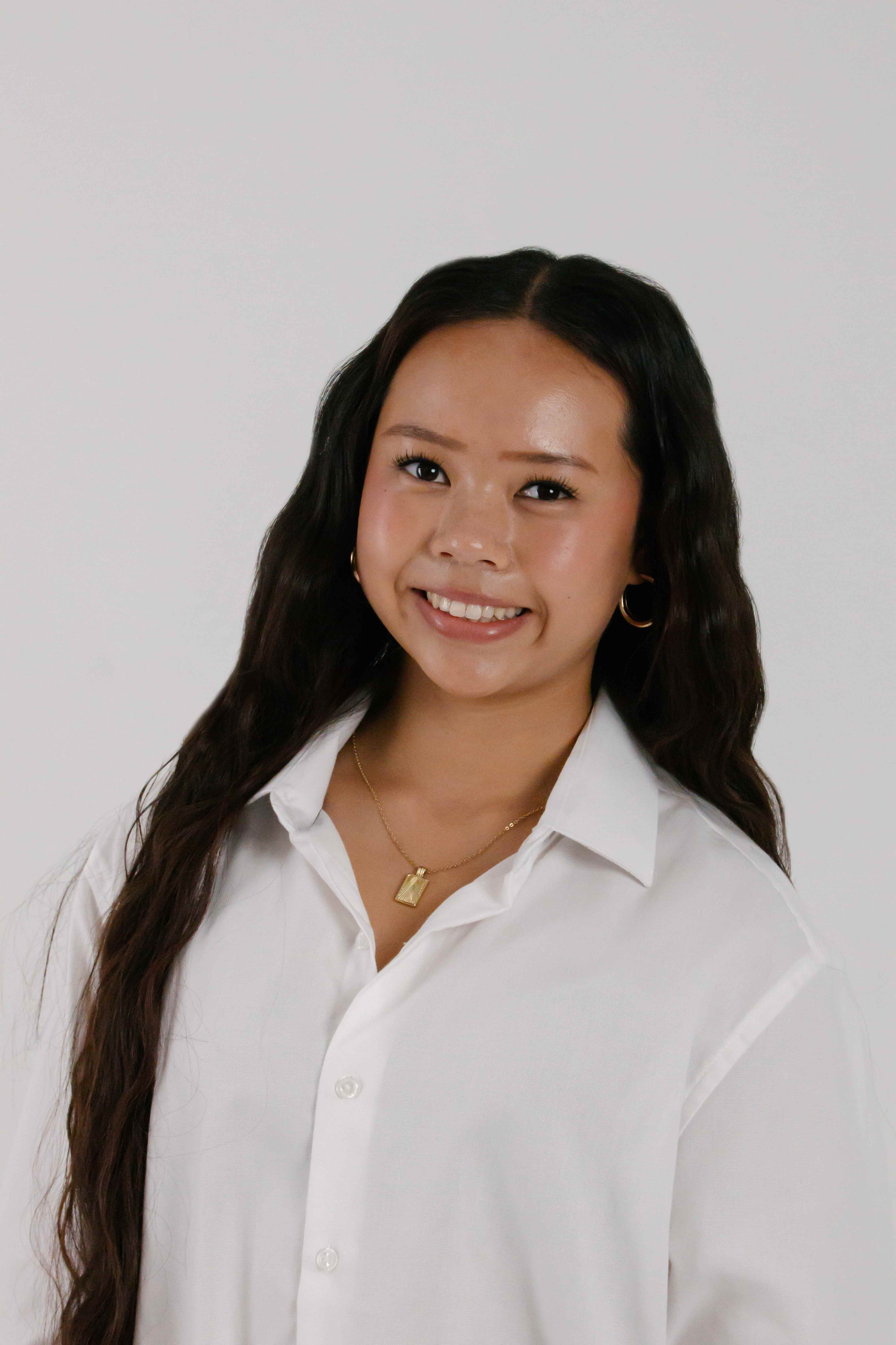 Portrait of dancer Arianna Luong smiling in a white button-up shirt