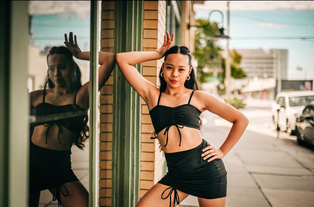 Arianna Luong posed with a hand on her hip against a storefront window